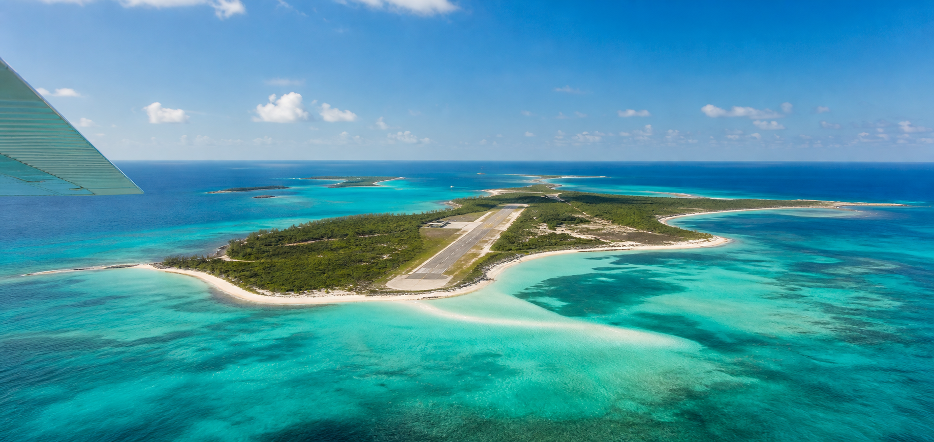 Aerial view from a general aviation aircraft over a turquoise Bahamian island airport